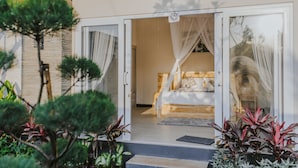 A bedroom with a bed, a canopy, and a view of the outdoors. - Rommy Villas Lembongan (Lembongan Island)