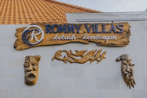 A sign for 'ROMMY VILLAS' with a logo and location 'Lebah - Lembongan'.