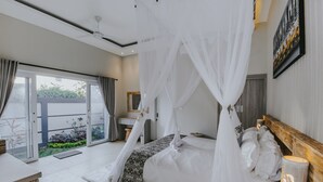 A bedroom with a canopy bed, a bedside table, a nightstand, a mirror, and a view of the outdoors. - Rommy Villas Lembongan (Lembongan Island)