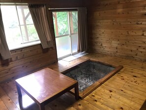 A wooden room with a window, a table, and a grill area. - Paseo Resort Club (Fujikawaguchiko)