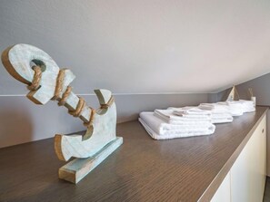 A wooden sculpture on a wooden table with folded towels in the background. - Apartment Sontje by Interhome (Opatija/Matulji)