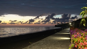 Ein Küstenweg mit Blick auf das Meer und einen Sonnenuntergang.