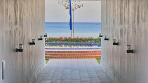 Ein Gang, der zu einem Pool mit Meerblick führt.