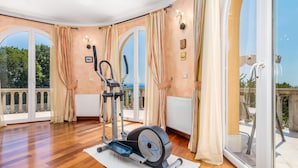 A spacious room with a large window, a stationary bike, and a radiator. - Awesome home in Opric (Opric)