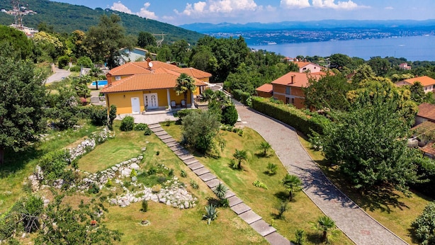 A residential area with houses, a paved pathway, and a body of water in the background. - Awesome home in Opric (Opric)