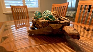 A wooden dining table with a centerpiece of natural materials and decorative items.