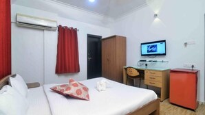 Une chambre d’hôtel équipée d’un lit, d’un bureau, d’une télévision et d’une armoire.