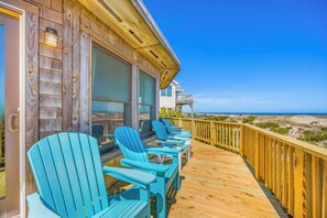 A wooden deck with chairs and a view of the beach. - Oceanfront Dog Friendly w/ Hot Tub, Game Room, Community Pool/Tennis/Pickleball (Avon)