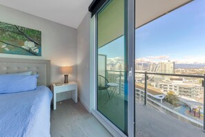 Enjoy a city view from the balcony, featuring a comfortable bed and a peaceful atmosphere.