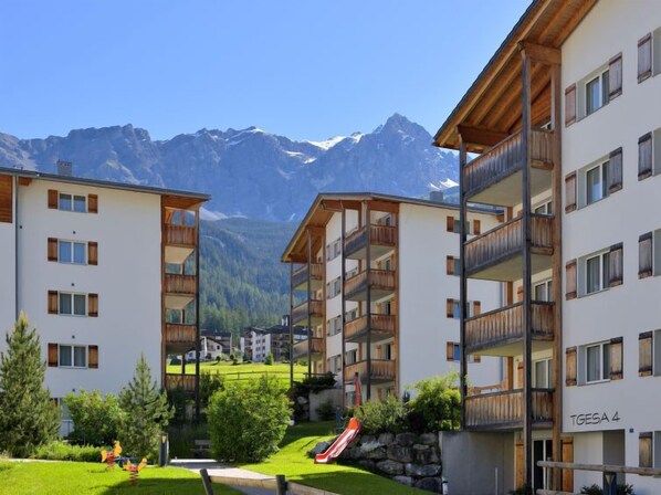 A modern apartment building with balconies, a ski slope, and a mountainous backdrop. - Surses Alpin by Interhome (Savognin)