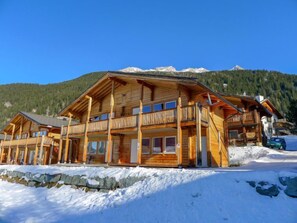 A wooden chalet with a balcony, set against a snowy mountain backdrop. - Sur Baselgia by Interhome (Savognin)