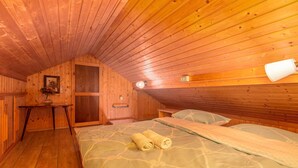 Une chambre mansardée chaleureuse avec des murs en bois et un plafond en pente.