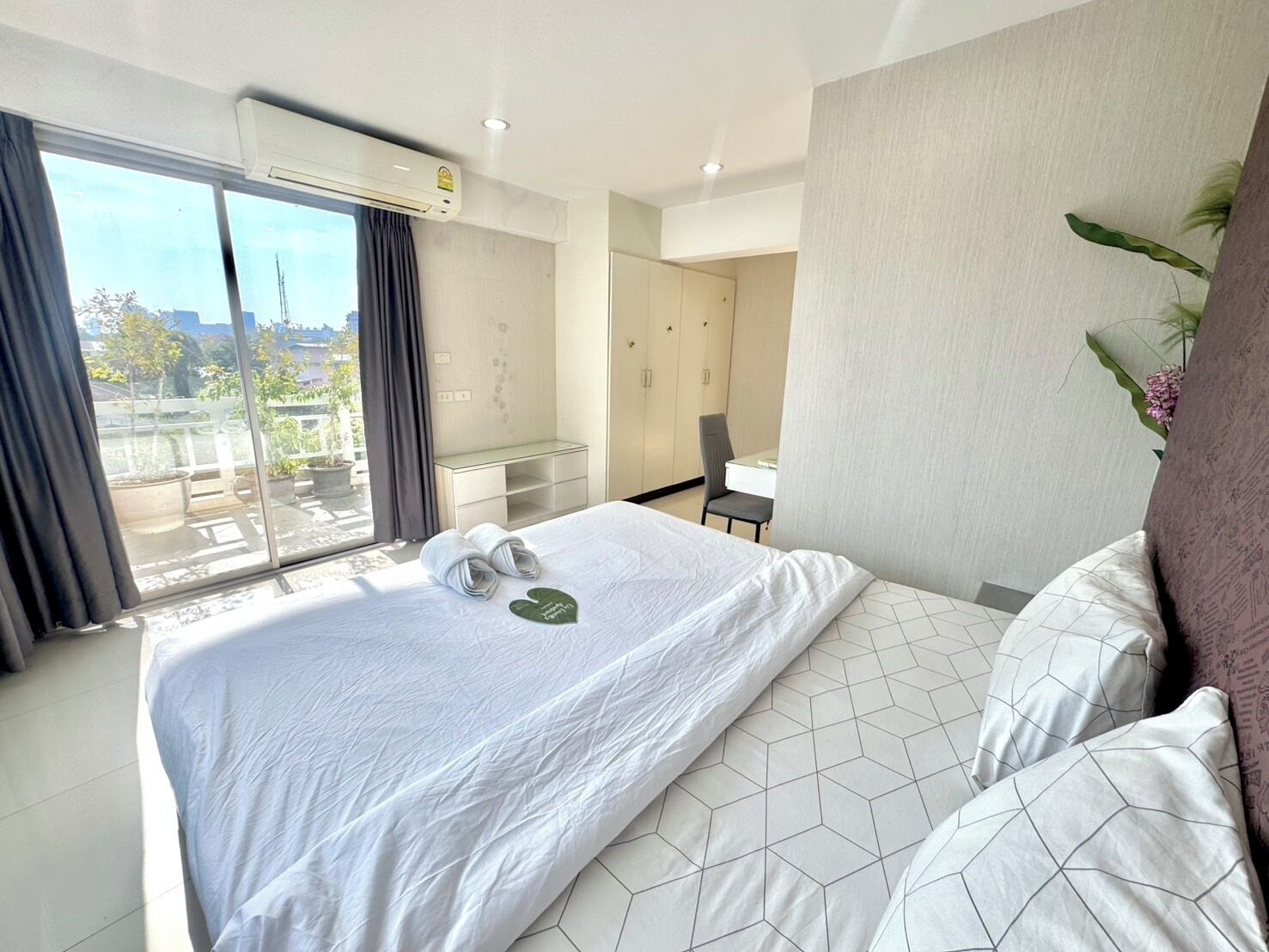 Une chambre d’hôtel moderne avec un grand lit, un bureau et une vue sur la ville.