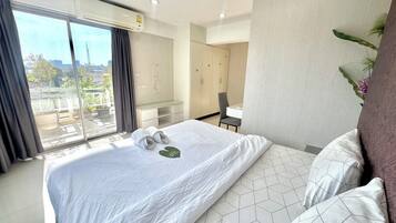 Une chambre d’hôtel moderne avec un grand lit, un bureau et une vue sur la ville.