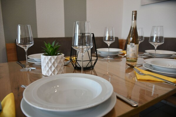 A dining table set with plates, wine glasses, and cutlery.