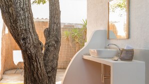 Une salle de bain avec un lavabo blanc, un miroir et un plancher en bois.