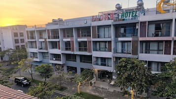A multi-story hotel with balconies, a rooftop water tank, and a sign reading "FLORA HOTEL".