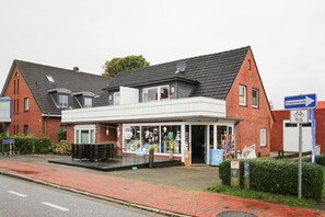 Un immeuble de deux étages avec une façade blanche et un toit gris.