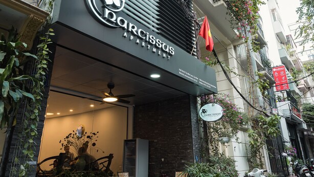 A modern building with a sign for 'Narcissus Apartments'. - Narcissus Hotel and Apartment (Hanoi)