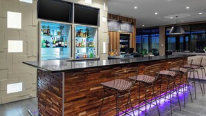 A modern bar area with wooden accents, a variety of liquor bottles, and bar stools.
