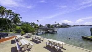 A waterfront park with picnic tables and a dock extending into the water. - Sunset Cove: One-Bedroom in Treasure Island (Treasure Island)