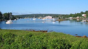 A calm harbor with boats, a building, and greenery. - Anchorage House & Cottages - Aspotogan Cottage (Hubbards)