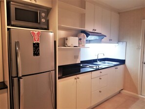 A compact kitchen with a refrigerator, microwave, toaster, and sink. - Jomtien Thip Condotel - Sleeps 2 Beachside (Pattaya)