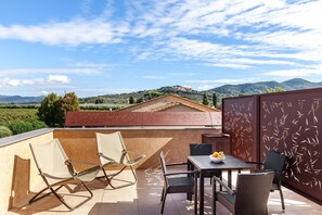 A rooftop terrace with a table, chairs, and a bowl of fruit. - Il Cru di Vignanova (Castagneto Carducci)