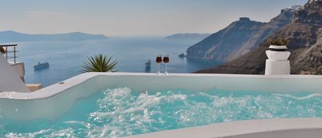 Una piscina infinita con vistas al mar y a la montaña.