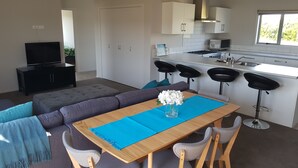 Een moderne woonruimte met een eethoek, keuken en zithoek.