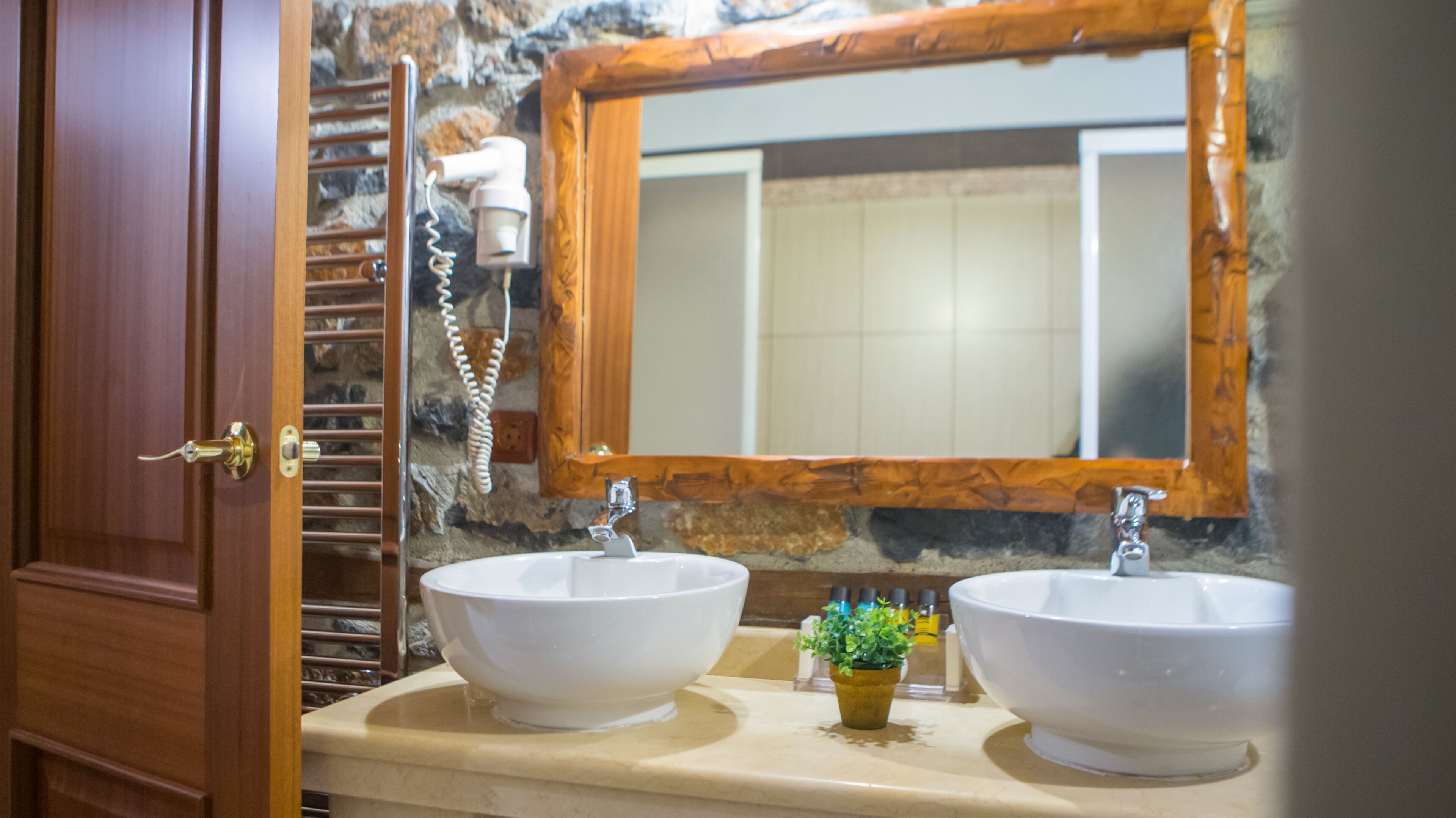 A bathroom with two sinks, a mirror, and a towel rack.