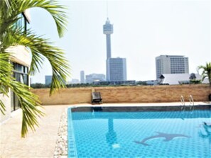 A swimming pool with a city skyline in the background. - Thepthip Mansion Pratumak - Studio Sleeps 2 (Pattaya)