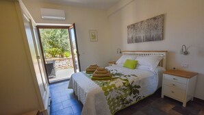 Une chambre à coucher comprenant un lit, une table de chevet et une commode, avec vue sur l’extérieur.