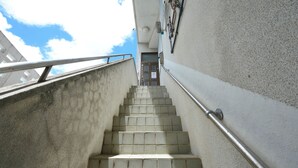 Eine Betontreppe mit Metallgeländern, die zu einer Tür mit einem Fenster führt.