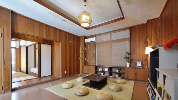 Ein traditioneller japanischer Raum mit Tatami-Böden, einem niedrigen Tisch und einem großen Spiegel.