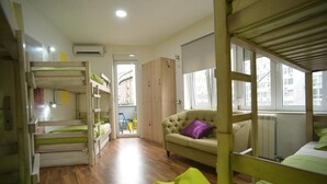 A dormitory room with bunk beds, a sofa, and a radiator. - Hostel Stella Di Notte (Belgrade)