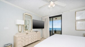 Une chambre d’hôtel avec un grand lit, une télévision, une commode, un miroir et un balcon avec vue.
