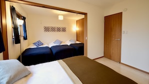 Ein Hotelzimmer mit zwei Betten, einer Holztür und einer Wandverzierung mit Muster.