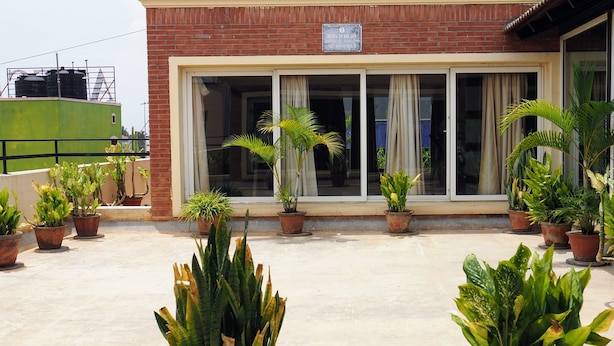 Un edificio con fachada de ladrillo, grandes puertas correderas de vidrio y varios maceteros en el suelo.