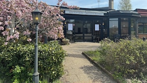 A reception area with a sign reading "RECEPTION RESTAURANG" and a pathway leading to the entrance.