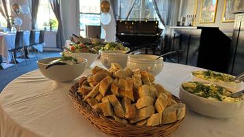A buffet table with various dishes and a piano in the background.