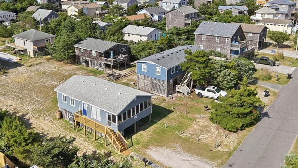 Un barrio residencial con casas, un muelle y un camión.