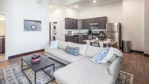 Een modern appartement met woonkamer, kitchenette en wasruimte.