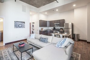 Eine moderne Wohnung mit Wohnzimmer, Küche und Waschbereich.