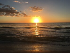 A sunset over the ocean with waves reflecting the sunlight. - The Beach House on Treasure Island—3 BR Coastal Retreat, 250 Steps to the Beach (Treasure Island)