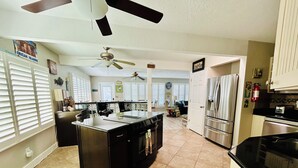 Una cocina amplia con una isla central, un refrigerador y una estufa.