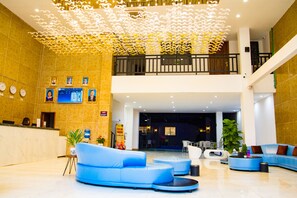 A spacious lobby with a reception desk, seating areas, and a decorative ceiling. - Junlan Hotel (Sihanoukville)