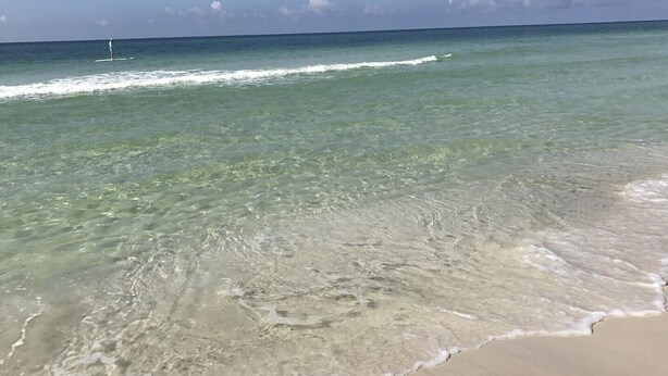 Een strand met helder ondiep water en een zandstrand.