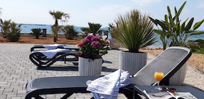 Relax in style with lounge chairs and refreshing drinks, overlooking the serene sea view.