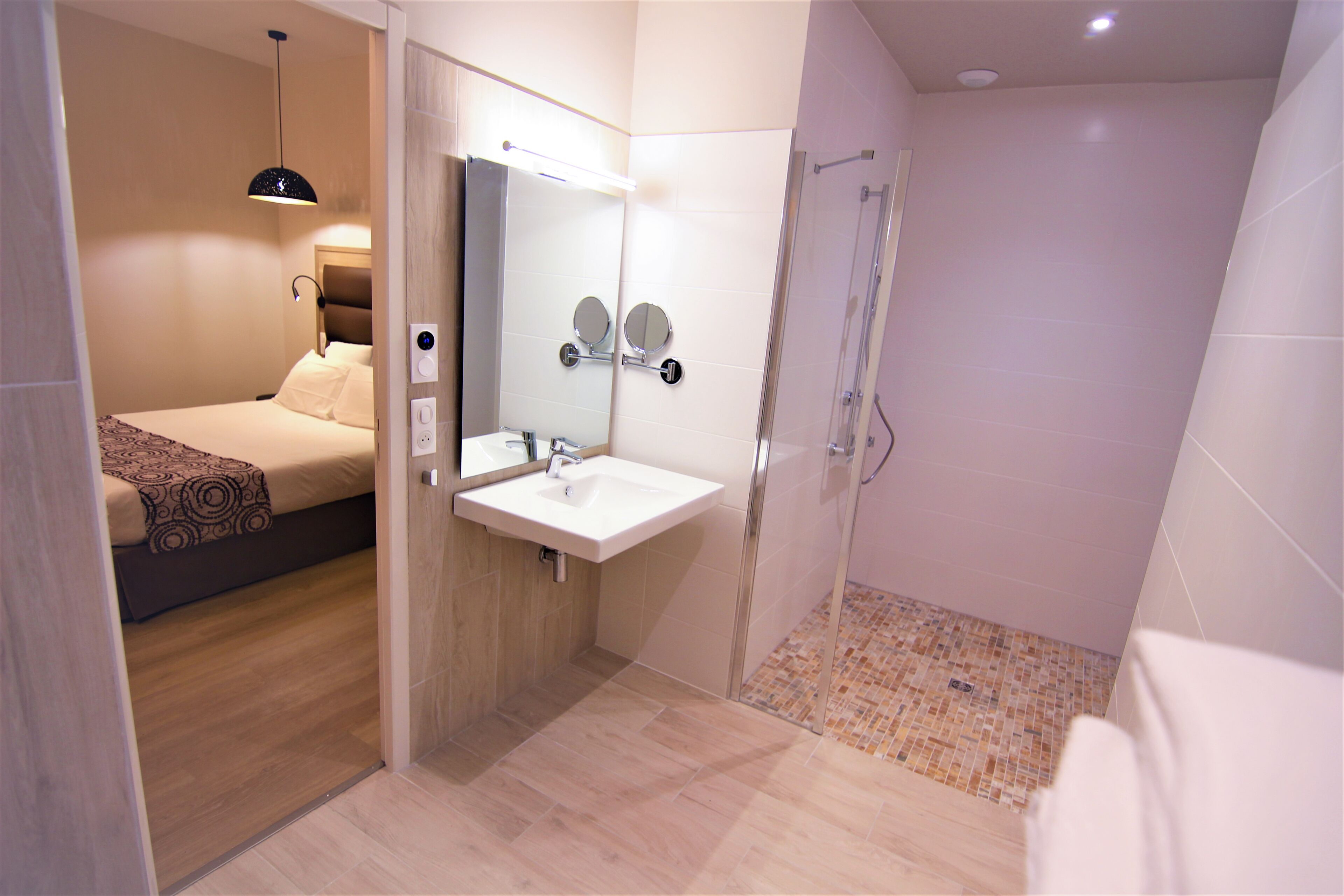 Un baño moderno con ducha, lavamanos y espejo.